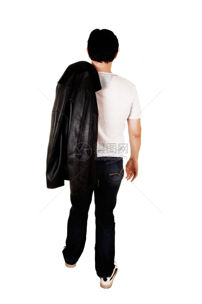 一个英俊的年轻人穿着黑色皮夹克从工作室的背面走过白色景图片