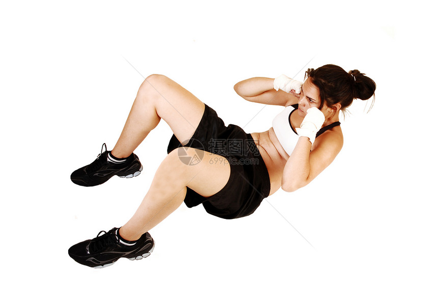 一个年轻女子准备拳击与艰苦的训练躺在地板上做了许多仰卧起坐为白色背景图片