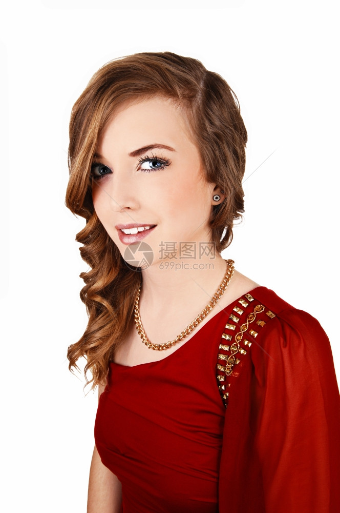 身着红色礼服长卷发的年轻美女站着XA白色背景微笑在镜头中xA图片