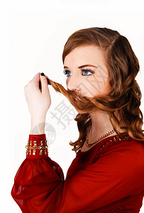 一位穿着红裙子的可爱年轻女嘴上长着头发站图片