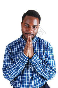一个年轻的黑人站在白背景的隔离地带折叠双手祷告图片