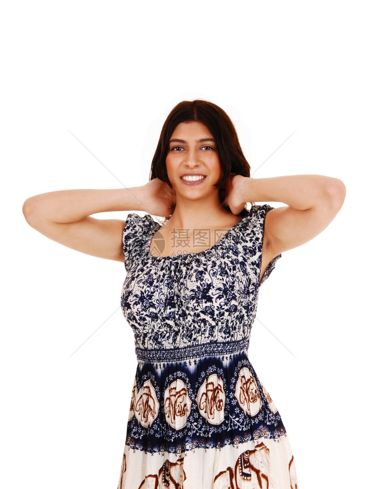 一位美丽的黑发女人 双手放在头后穿着的裙子 与白种背景隔绝图片