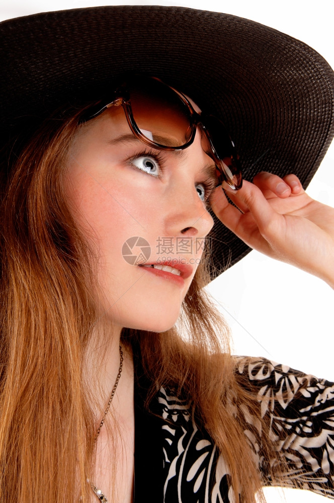 一个黑帽子和太阳镜的黑头发年轻女人被白色背景隔绝的照片图片