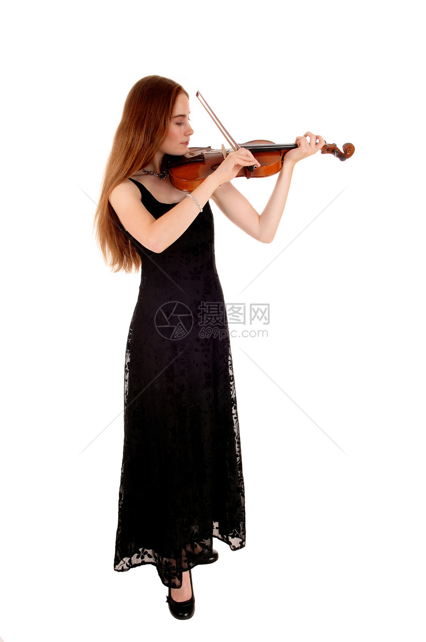 一个穿着长黑裙的瘦年轻女人站在白背景上玩小提琴图片