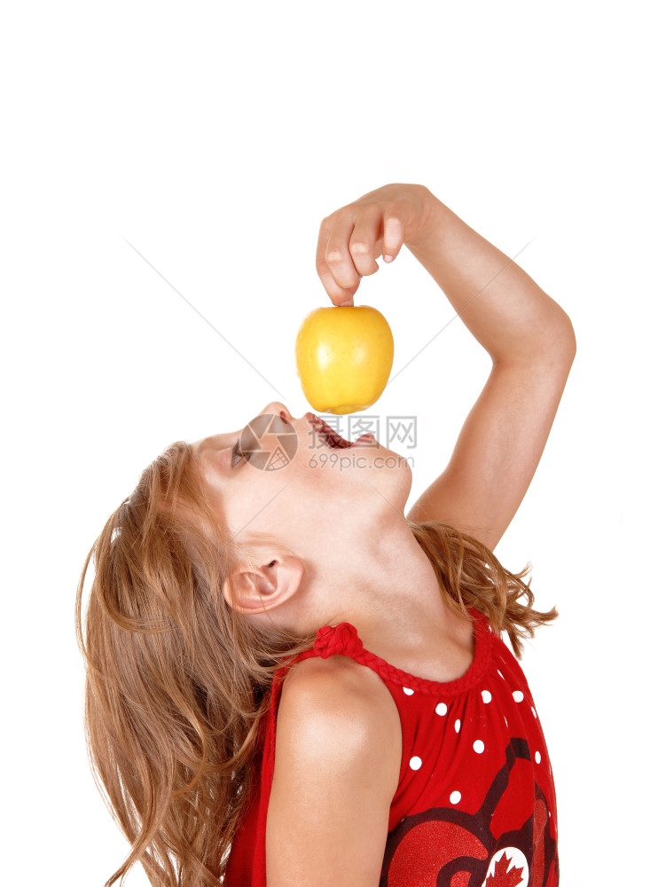 一个金发女孩在玩她的黄苹果喜欢吃孤立的白色背景图片