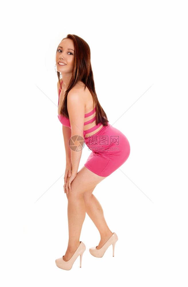 一个美丽的年轻亚洲女人穿着粉红色的裙子站在侧面孤立的白色背景图片