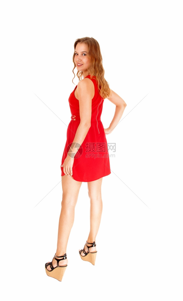 一位美丽的年轻女穿着红裙子看她的肩膀与白种背景隔绝图片