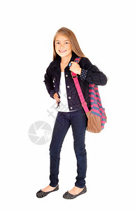 一个可爱的金发年轻女学生站在白背景的孤立位置背着包在肩膀上图片