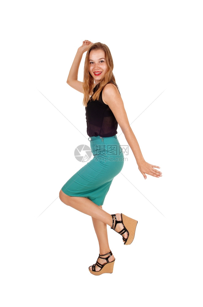 穿着绿裙子的可爱年轻女人穿着黑色上衣在工作室里跳舞白背景的黑衣舞图片