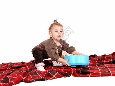 一个可爱的小女孩在地上玩具的毛毯图片