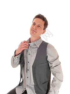 一个穿着灰色衬衫领带和背心的年轻人带着他的领白背景孤立无援图片