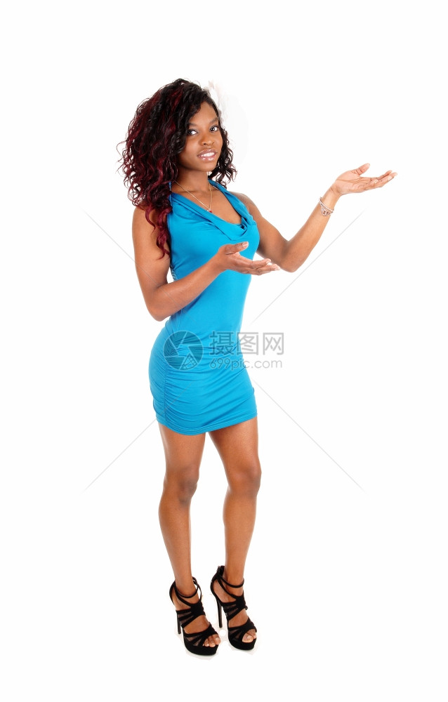 一个瘦弱的年轻非裔美国女人穿着短蓝色裙站立不动的白色背景手举露面图片