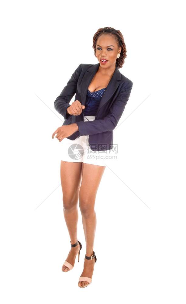 身穿白短裤着灰色夹克和高跟鞋的瘦弱非裔美国女人站着与白隔绝图片