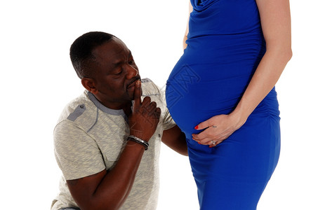 一位非裔美国人跪在白女面前好奇大肚子的婴儿与白人隔绝图片