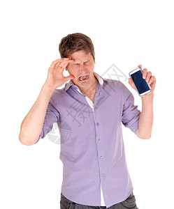 一个年轻人站在哭泣的孤立白人背景拿着他的破碎手机图片