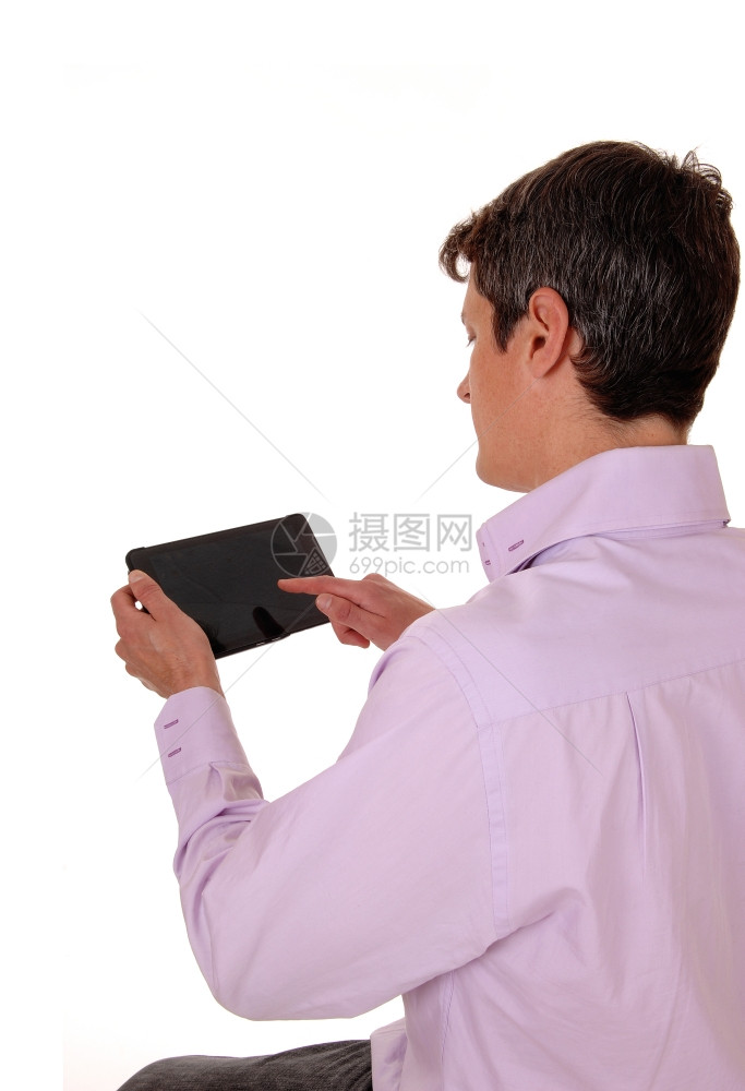 一个年轻人从背面看在他的平板上工作孤立的白色背景图片
