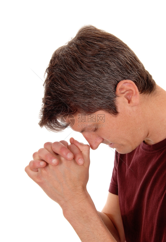 一个手折着的年轻人在特写中祷告与白种背景隔绝图片