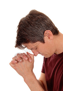 一个手折着的年轻人在特写中祷告与白种背景隔绝图片