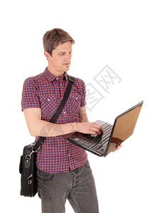一名年轻人站在白背景的隔离区拿着笔记本电脑肩上拿着公文包图片