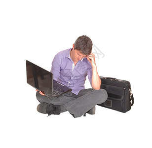 一个坐在地上的人拿着笔记本电脑思考问题图片