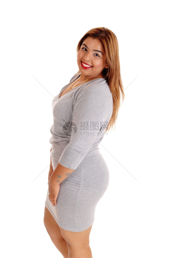 一个穿灰色紧身衣的黑发年轻女人站在白皮底下微笑着图片