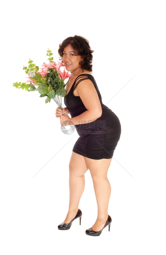 一位身着黑衣的混血女子站在白人背景的侧面拿着一束花朵图片