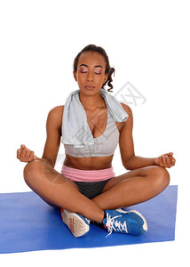 一名参加运动的非洲女孩在瑜伽姿势的垫子上穿衣图片