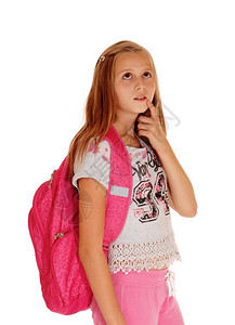 一个金发美女站在她的粉红色背包上学寻找升和思考孤立的白色背景图片