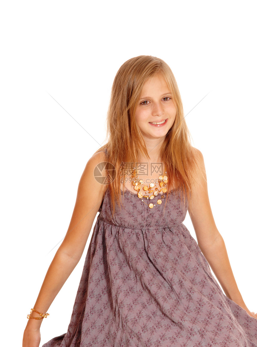 一个快乐的小女孩穿着勃朗古迪的裙子微笑坐在地板上与世隔绝的白色背景图片