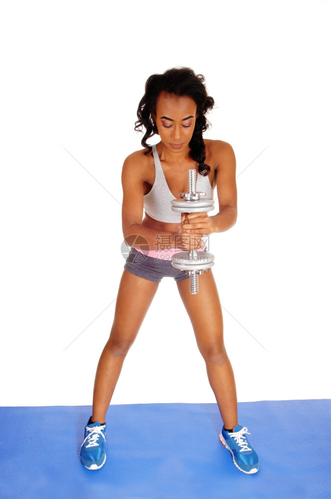 一位美丽的非洲裔年轻女站在蓝色的垫子上与白种背景隔绝图片