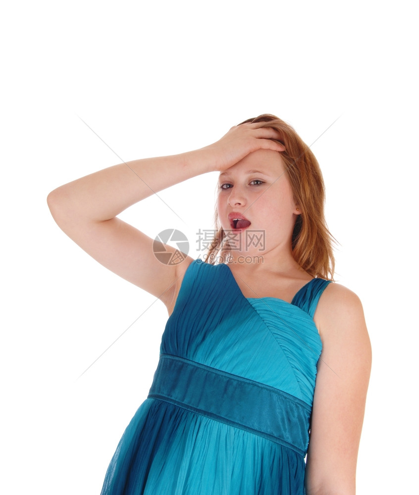 一个穿蓝裙子的漂亮女孩被她的手放在前额张开的嘴上震惊被白背景隔离图片