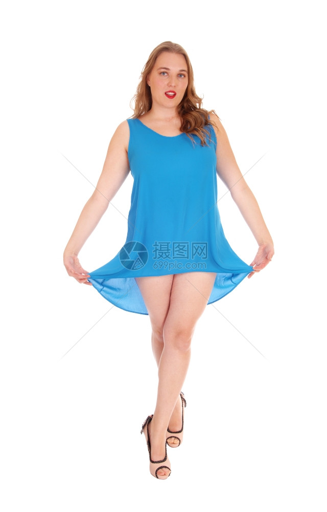 整个身体的图像一个年轻女子站在蓝色的裙子高跟鞋脱衣她的服隔离为白色背景图片
