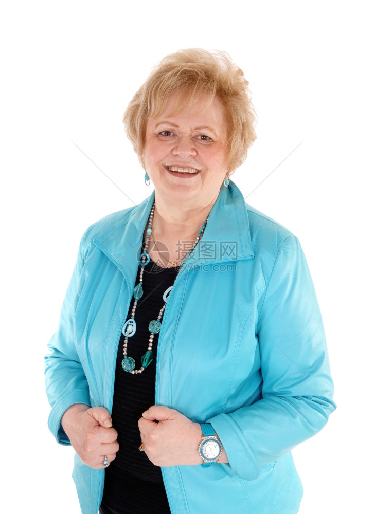 一个穿着蓝色夹克的金发老妇人笑着站为白种背景而孤立的腰部图片