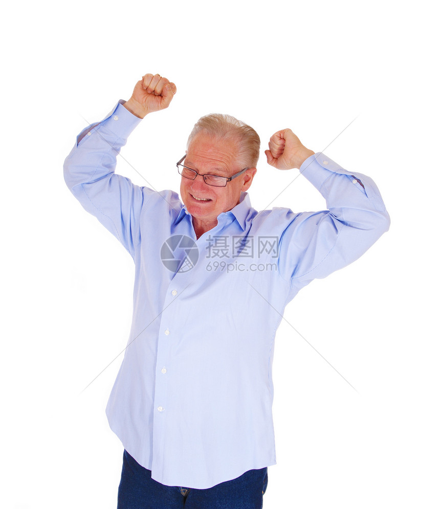 一个愤怒的老人举起他双臂面露严酷的脸站在蓝色衬衫上被白背景所隔离图片