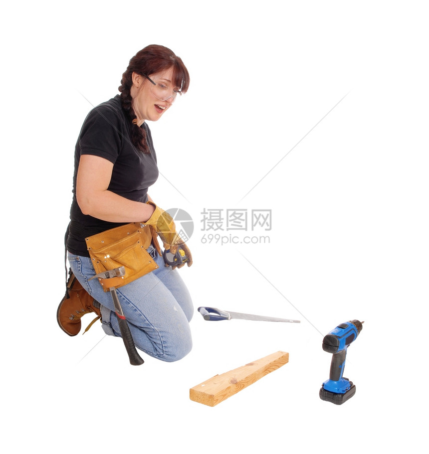 一位中年妇女跪在地上用一些工具作为白种背景而孤立无援图片