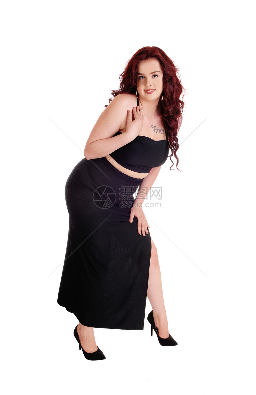 一个穿着长黑裙子的可爱年轻女红发白种背景的红发图片