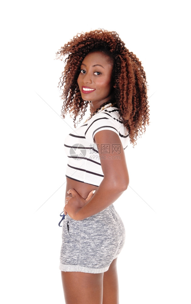 一位美丽的非裔国女穿着短裤站在侧面微笑镜头中与白人背景隔绝图片