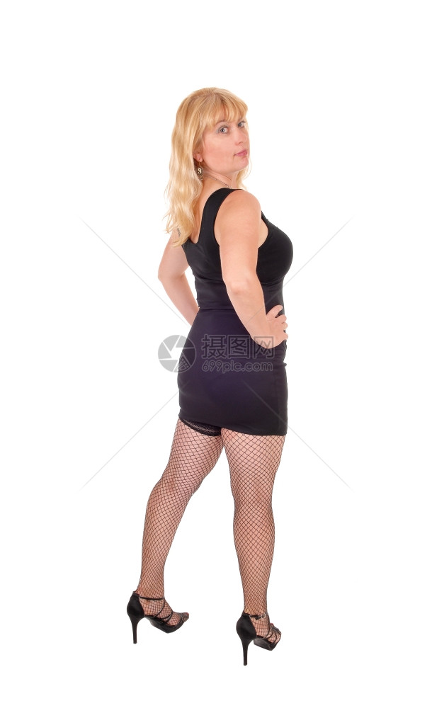 一个四十多岁的美女站在背面的黑色晚礼服上与白色背景隔绝图片