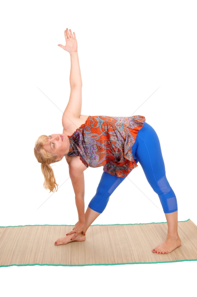 一个漂亮的女人金发长在马特瑜伽姿势孤立的白色背景图片