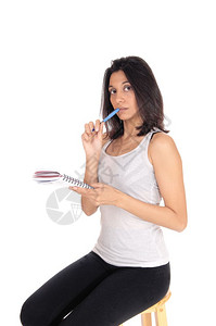 一个黑发女人坐着不说话用蓝色笔的缝合孤立白色背景图片