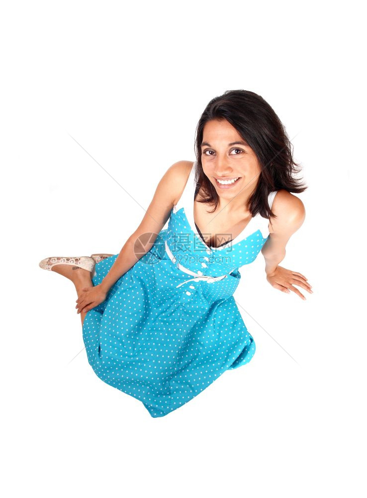 一位美丽的西班牙女青年穿着蓝礼服坐在地板上微笑与白人隔绝图片