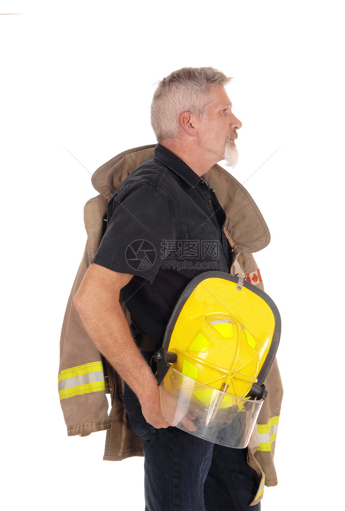 一个中年消防员男子穿着外套站在侧肩上手戴着头盔被白背景隔离图片