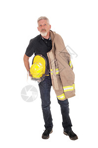 一名中年消防员站在前面背着夹克肩上穿外套手戴头盔因白背景被隔离图片
