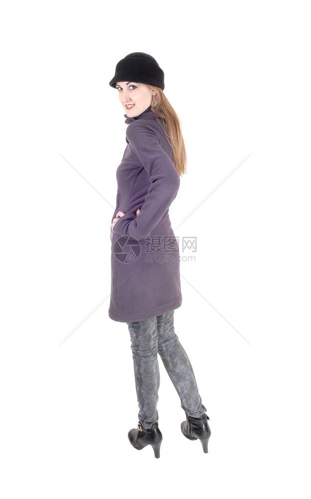 一位美丽的黑发女人穿着蓝色的冬大衣和帽子长着脸谱与白色背景隔绝图片
