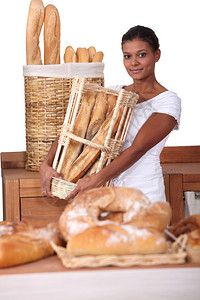 在面包店的里拿着一篮面包的年轻女子图片