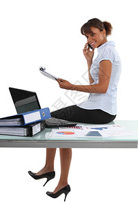 女商人在工作时坐办公桌旁图片
