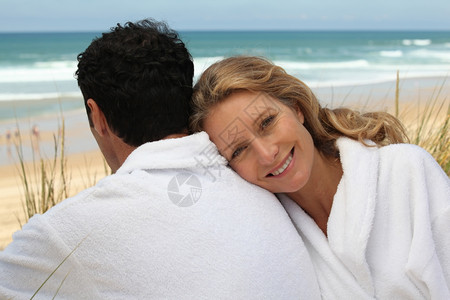 在沙滩上的浴袍中情侣图片