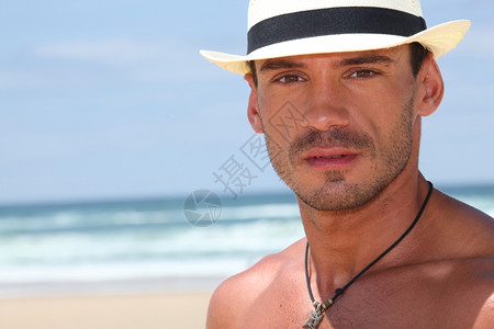 在沙滩上戴帽子的男人图片