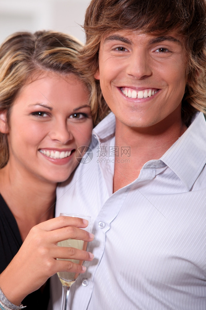 有牙笑和长笛酒的年轻夫妇图片