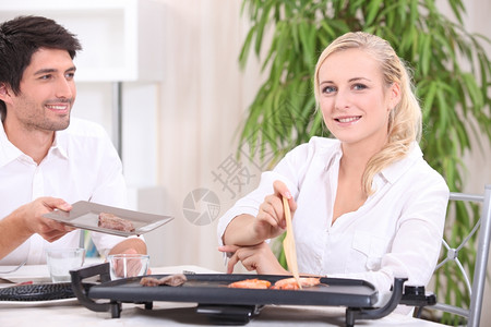 一对夫妇吃用电机煮的饭高清图片